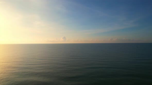 Aerial view from a drone, waves in the orange sea Sunset