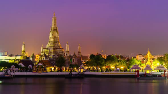 night to day time lapse of Wat Arun Temple with Chao Phraya river in Bangkok, Thailand