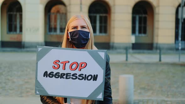 Protest Walk: Woman in Protective Mask Protesting To Stop Aggression By Holding Steamer