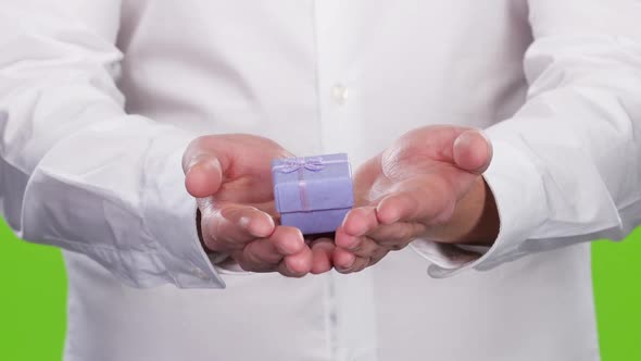 Small Gift Box in a Man's Hands. Close Up. Studio