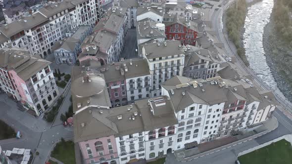 Aerial View Flying Over Touristic Hotel Area Surrounded By Mountains Valley Landscape at Sunrise