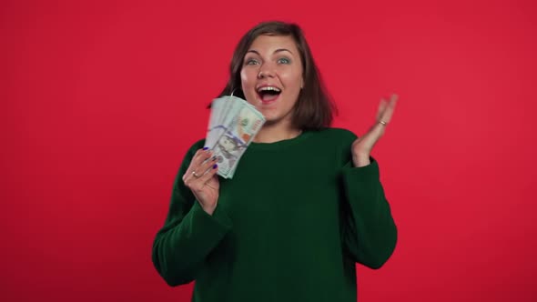 Happy Excited Girl in Green Sweater Showing money-U.S. Currency Dollars Banknote