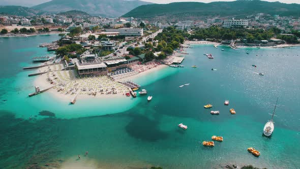 Aerial Azure Beach with Empty Sun Loungers and Boats Balkan Sea Coast Albania