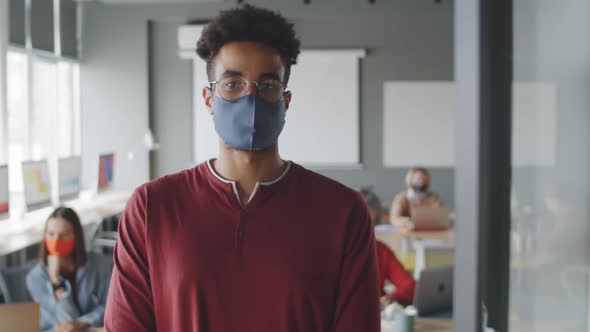 Portrait of Young Man in Protective Mask in Office