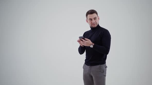 Half length portrait of man holding a mobile phone