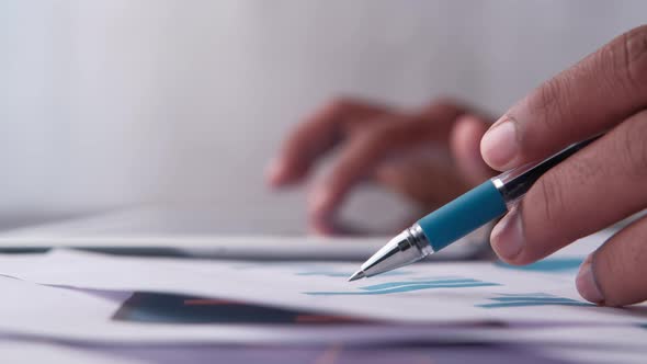 Man Hand with Pen Analyzing Bar Chart on Paper 