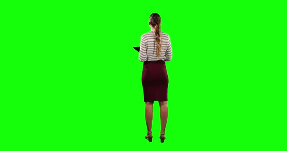 Rear view of a woman holding a digital tablet with green screen