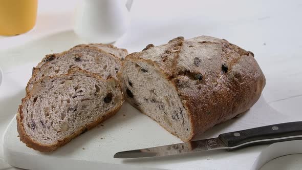 Closeup of Sliced Pieces and Half of Rye Raisin Bread on the White Table