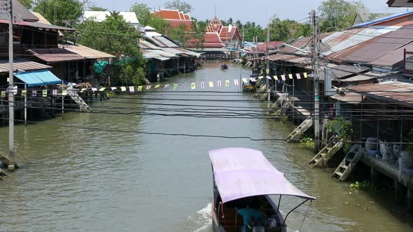 Overview from the Tha Kha Floating Market with a boat passing by