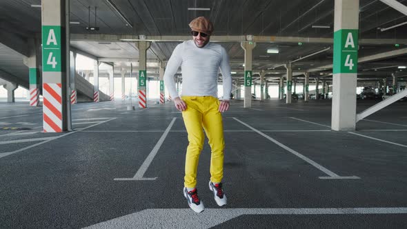 Cheerful and Happy Young Man with Beard Actively Is Dancing While Walking Down the Street on Urban