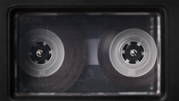 Vintage Transparent Audio Cassette Playing in Deck of an Old Tape Recorder