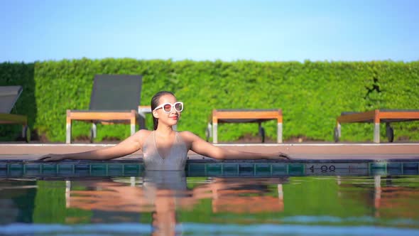 Young asian woman enjoy around outdoor swimming pool for leisure