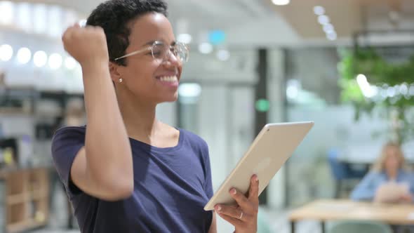 Portrait of Casual African Woman Celebrating Success on Tablet 