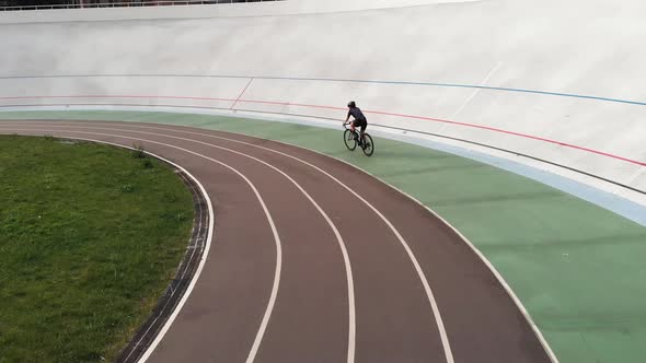 Attractive Girl on Road Bike Is Riding on Bicycle Path at Velodrome