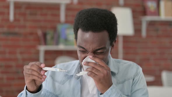 African Man Checking Temperature with Thermometer 