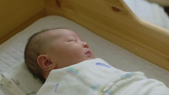 Baby sleeping in bed. East Asian.