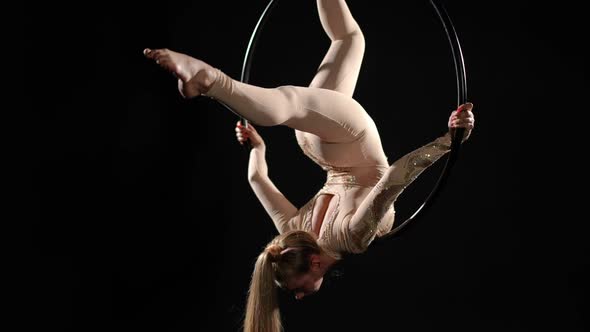 Flexible Barefoot Slim Young Woman Hanging Upside Down on Air Hoop in Split Performing Trick