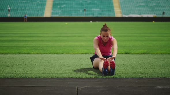 Athletic Girl Doing Exercises at the Stadium