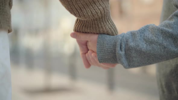 Close-up of Grandfather and Grandson Holding Hands. Unrecognizable Male Retiree and Little Caucasian