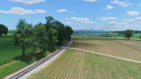 Aerial View of a Steam Engine Puffing Smoke and Steam with Passenger Coaches Traveling