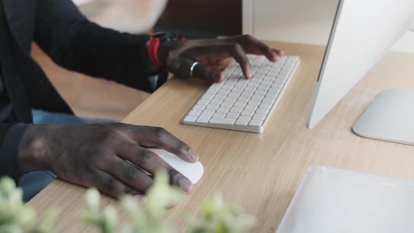 Black Man Works at a Computer