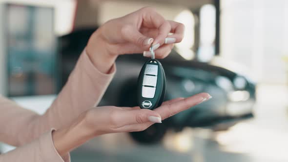 Car Dealer Giving Keys to a Customer Against Cars Parked