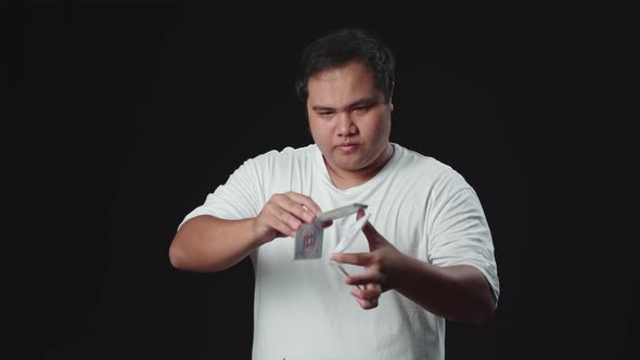 Asian Man Showing His Trick With Usual Cards, Cardistry On Black Background