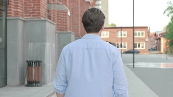 Back View of Man Walking in a Street