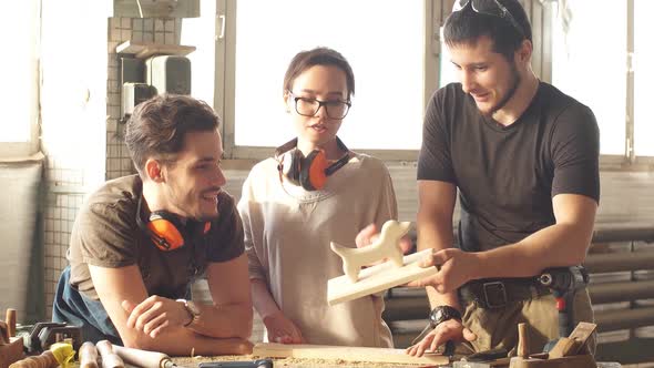 Male Carpenter Showing Colleagues His New Product.