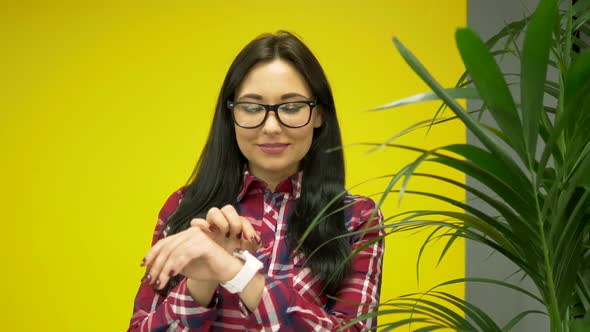 Hipster Mixed Race Woman Using Smartwatch on Yellow Background