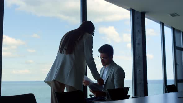 Office Secretary Showing Businessman Financial Documents at Panorama Window