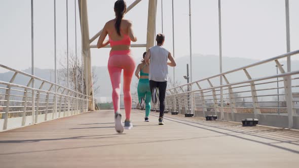 Group of runners jogging on bridge