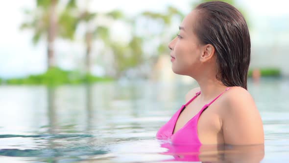 Young asian woman enjoy around outdoor swimming pool for leisure