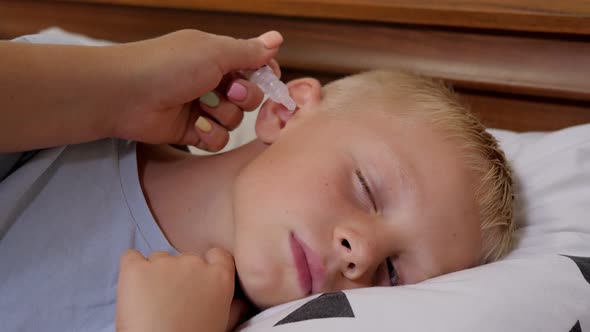 Doctor Drips Medicine Into the Ear of a Sick Boy