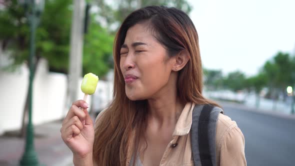 Young Woman Showing Thumbs Up with Popsicle Ice Cream in Outdoor Scene