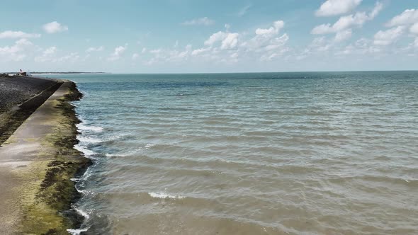 Aerial View From Above on a Tropical Island and Ocean Waves Crashing and Foaming Against Sand Beach