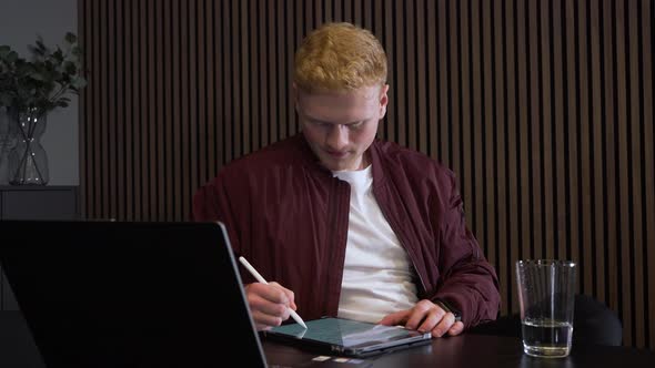 Close up shot of a redhead man taking notes