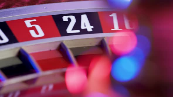 A Casino Roulette Wheel with a White Ball on Green 0