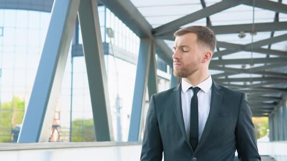 Businessman in Suit Walking Near the Business Center Adjusting Suit and Tie