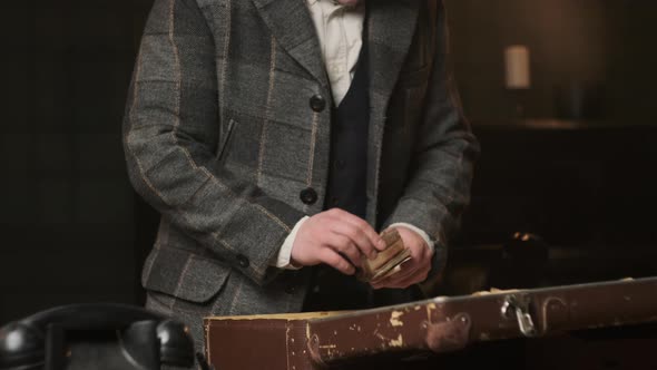 Mafia Gangster in Plaid Suit Gets His Loot in Form of Old Money From Suitcase of Brown Leather