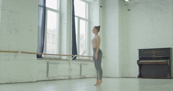 Ballerina Practicing Ballet Leap in Dance Studio
