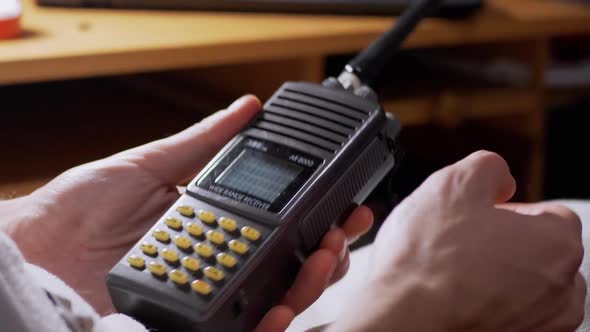 Male Turns on WalkieTalkie Adjusts Frequency Volume of Connection in Room