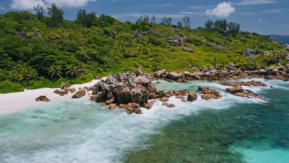 Aerial Circle Footage of Huge Granite Rocks and Ocean Waves in Lagoon of Anse Coco Tropical Paradise