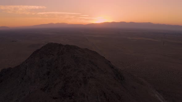 Mojave Desert mountains during fire sunrise or sunset in California, Aerial Pan