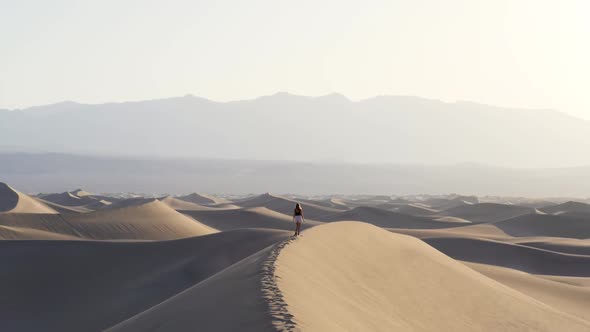 Ultra slow motion shot of woman walking on sand dune in the desert in Death Valley National Park in