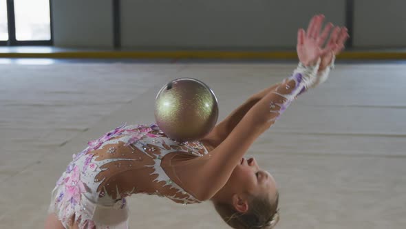 Teenage female gymnast performing at sports hall