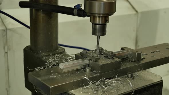 Worker making holes in metal plates with a punching drilling machine