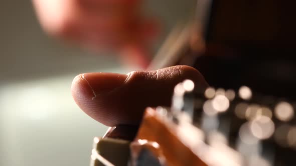 Male hands plucking acoustic guitar strings. Macro shot close up, solo player.