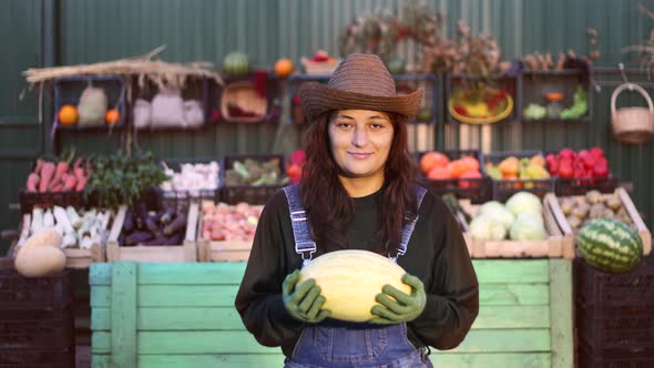 Woman Farmer (Seller) With Melon at the Farmer's Market.