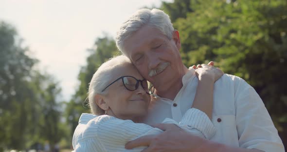 Close Up of Happy Senior Couple Embrace Spending Time Together in Beautiful City Park